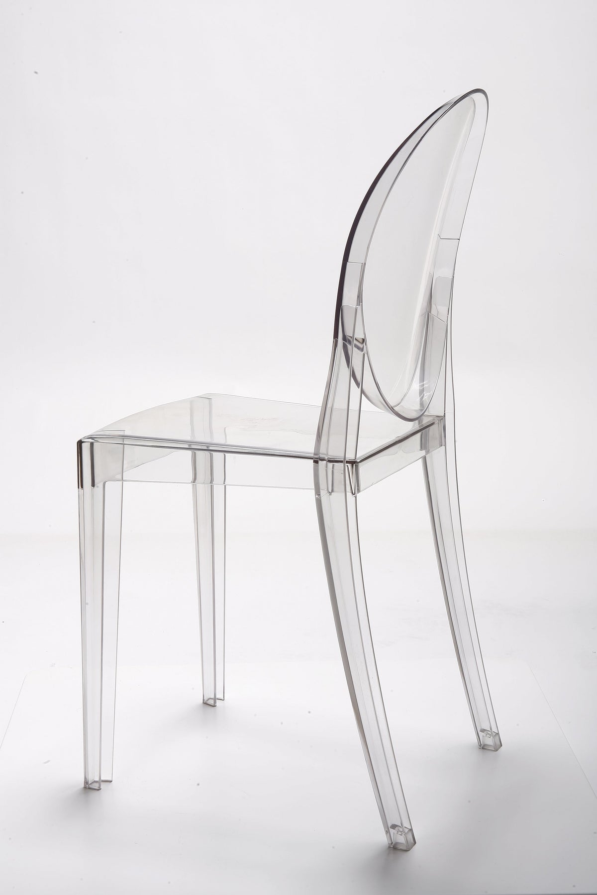 Rear three quarter view of the clear acrylic dining chair, showing the moulded back and seat join