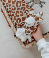 A person holding a Giraffe Snuggly stuffed animal made with Oeko-tex® certified cotton by Bengali Collections.