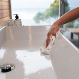 A person cleaning a sink with a Good Change REUSABLE BAMBOO TOWEL.