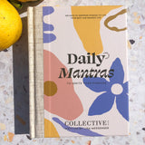 A book titled "Daily Mantras to Ignite Your Purpose Version 3" by Collective Hub next to a lemon.