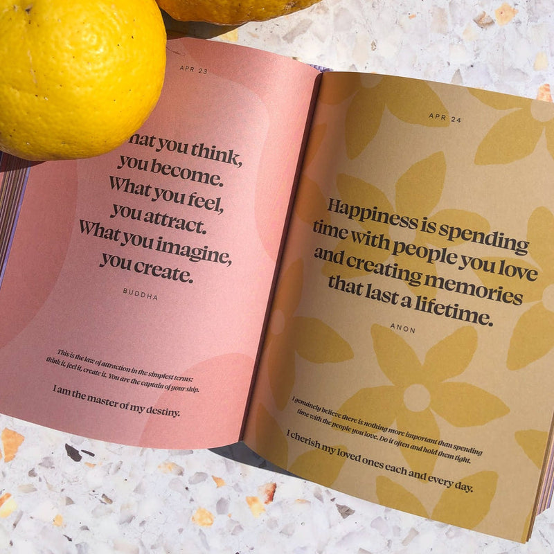 Collective Hub's book, "Daily Mantras to Ignite Your Purpose Version 3," filled with inspiring quotes and including a powerful reflection on happiness and lemons.