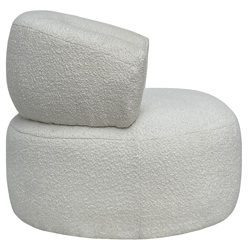 Side profile of the boucle armchair, showing the low seat and angled back rest