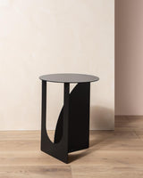 A modern Arch Side Table ∙ Black by Made of Tomorrow on a wooden floor.