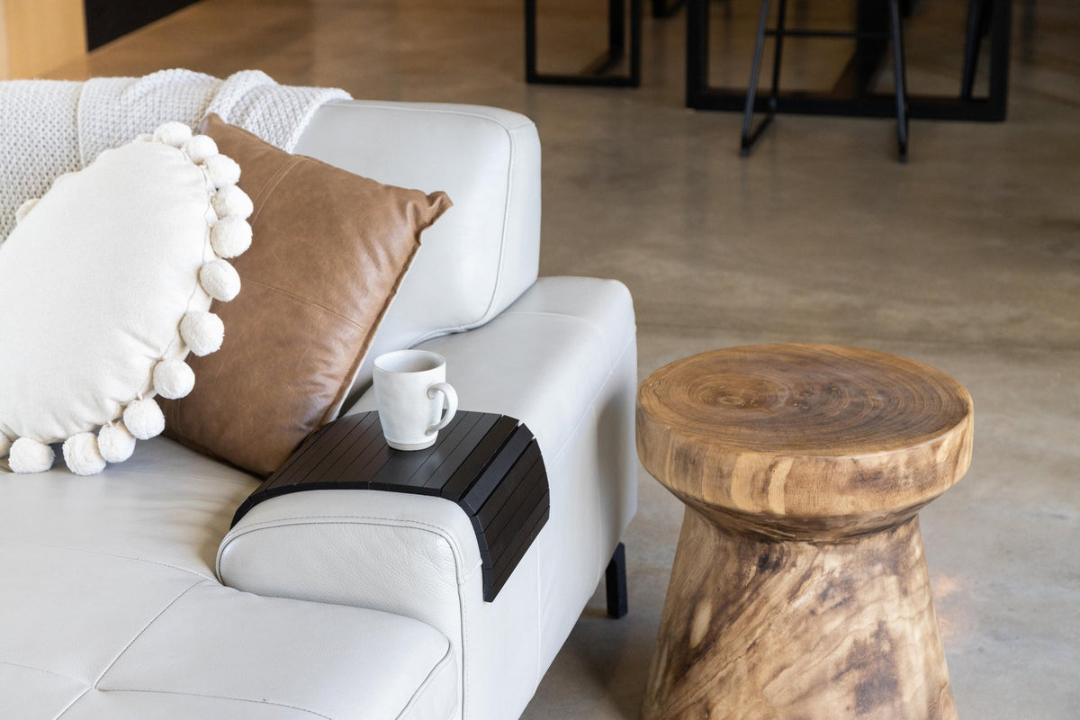 Ned Collections Arm Chair Side Rest resting on a sofa arm beside cushions and a coffee table