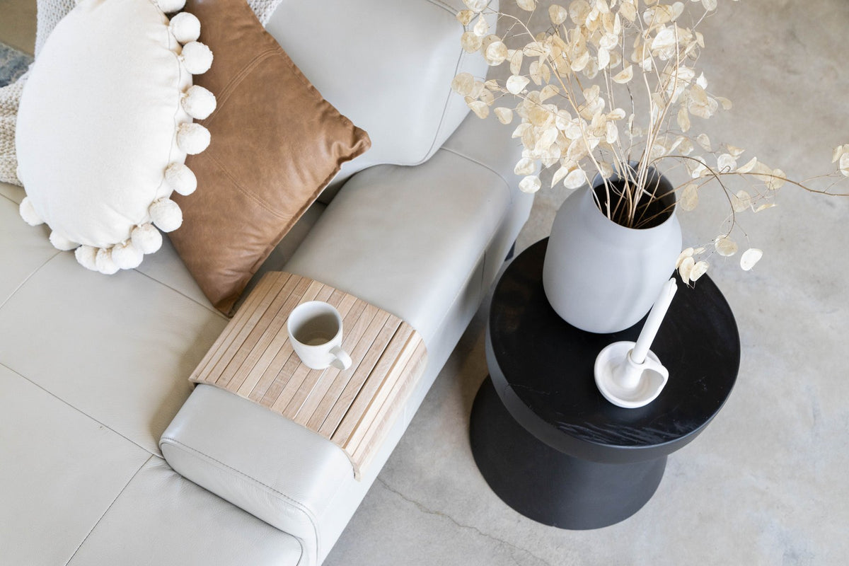 Ned Collections arm chair side rest in a living room beside a vase of flowers