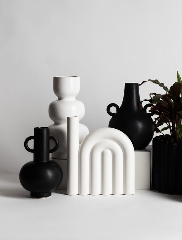 A group of black and white LOUIS vases on a white surface, featuring the Sven vase from Ned Collections.