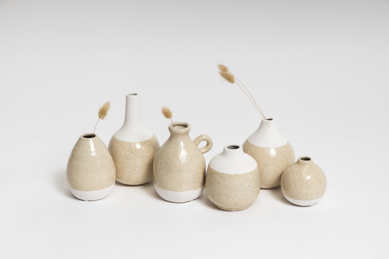 A collection of beige and white CHARLIE VASES on a white surface from Ned Collections.