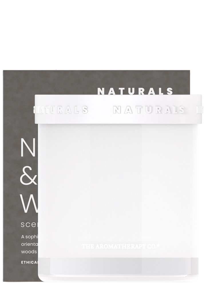 Naturals candle in frosted white glass standing in front of its charcoal gift box
