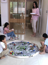 A group of children engaging in interactive play with a Play Pouch Wow Town Track Interactive.