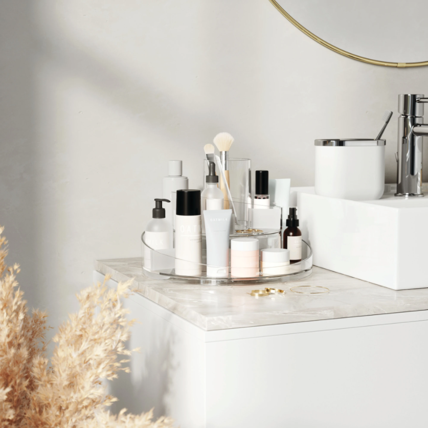 Umbra Cascada rotating organiser on a marble vanity holding skincare and brushes