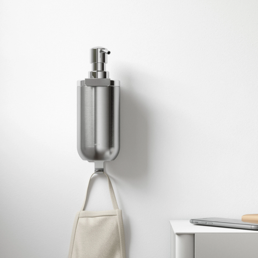 Umbra Junip wall mounted soap pump in stainless steel above a hanging towel
