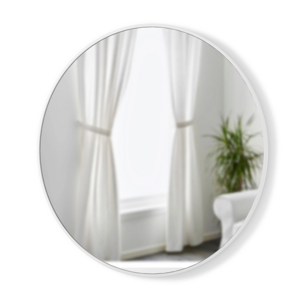 A versatile Umbra HUB WALL MIRROR - White 94cm hangs on the wall of a room adorned with white curtains and a potted plant.