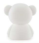 A Boris First Light Lamp by Mr Maria, a white teddy bear with an LED module, serving as a nightlight, sitting on a white surface.
