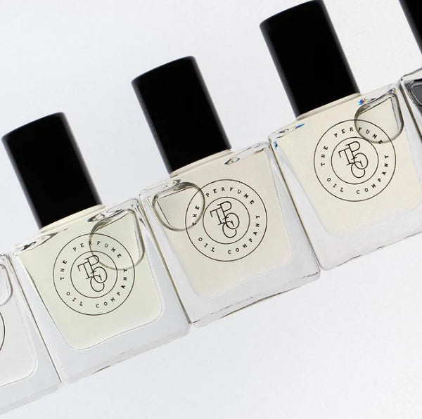 Row of square perfume oil roll-on bottles on an angle on a white surface