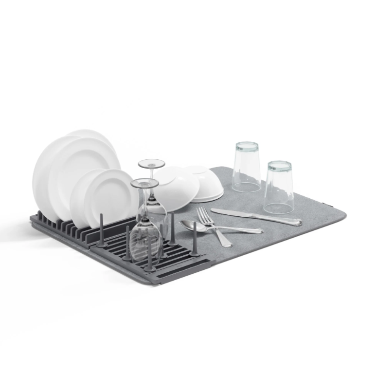 An Umbra UDRY PEG DRYING RACK WITH MAT with dishes on it.