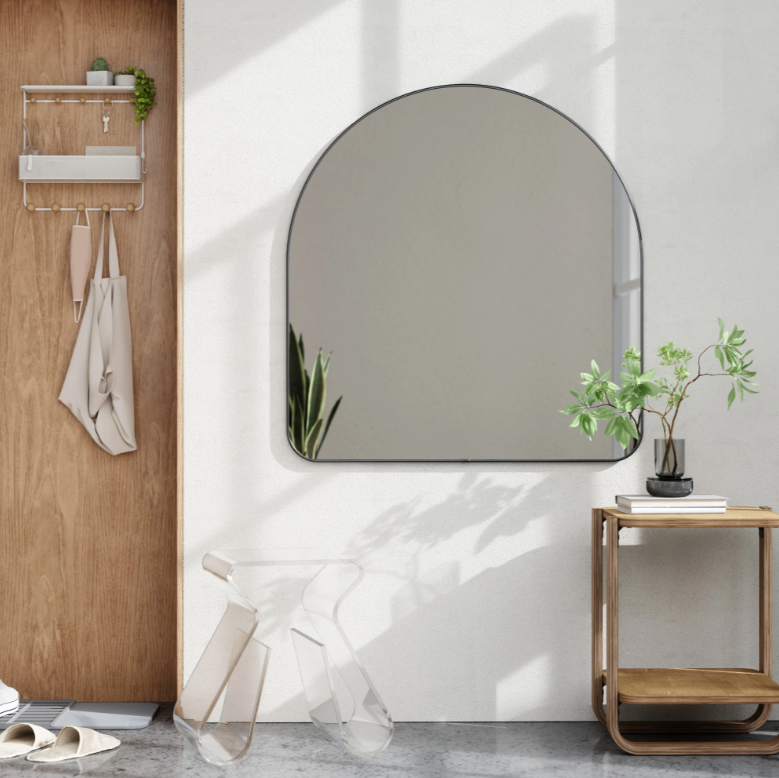 Umbra Hubba arched mirror in titanium in an entryway beside a timber console
