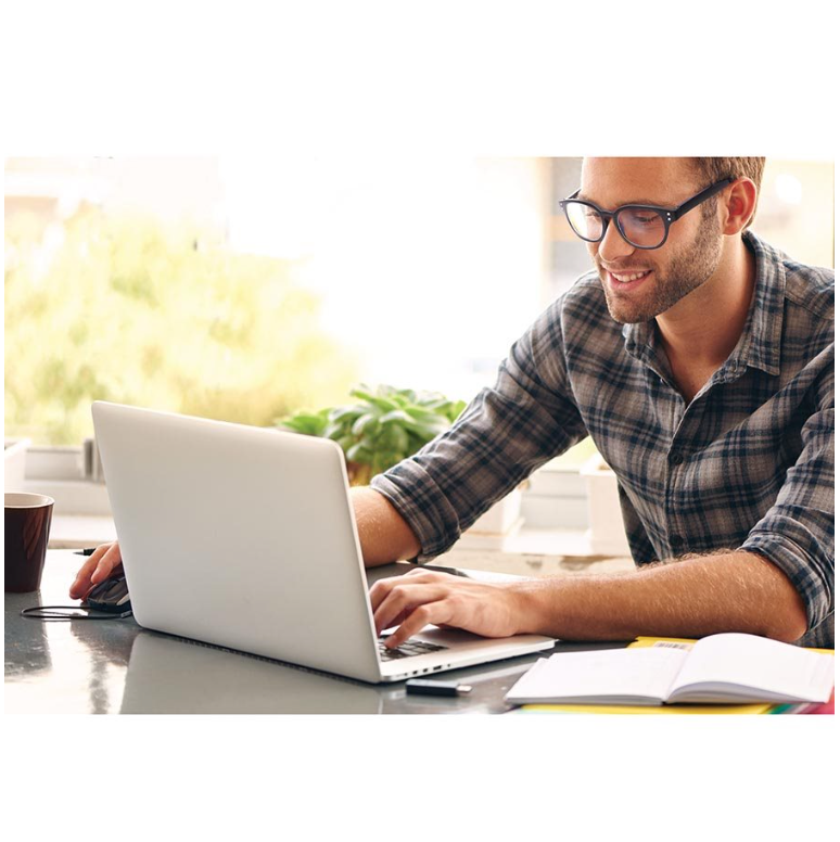 Man wearing glasses while working on a laptop