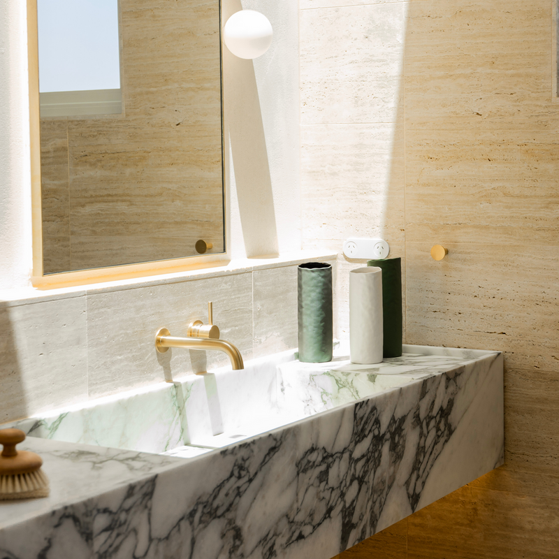 A bathroom with a marble sink featuring a Ned Collections Bernie Vase - Various Options.