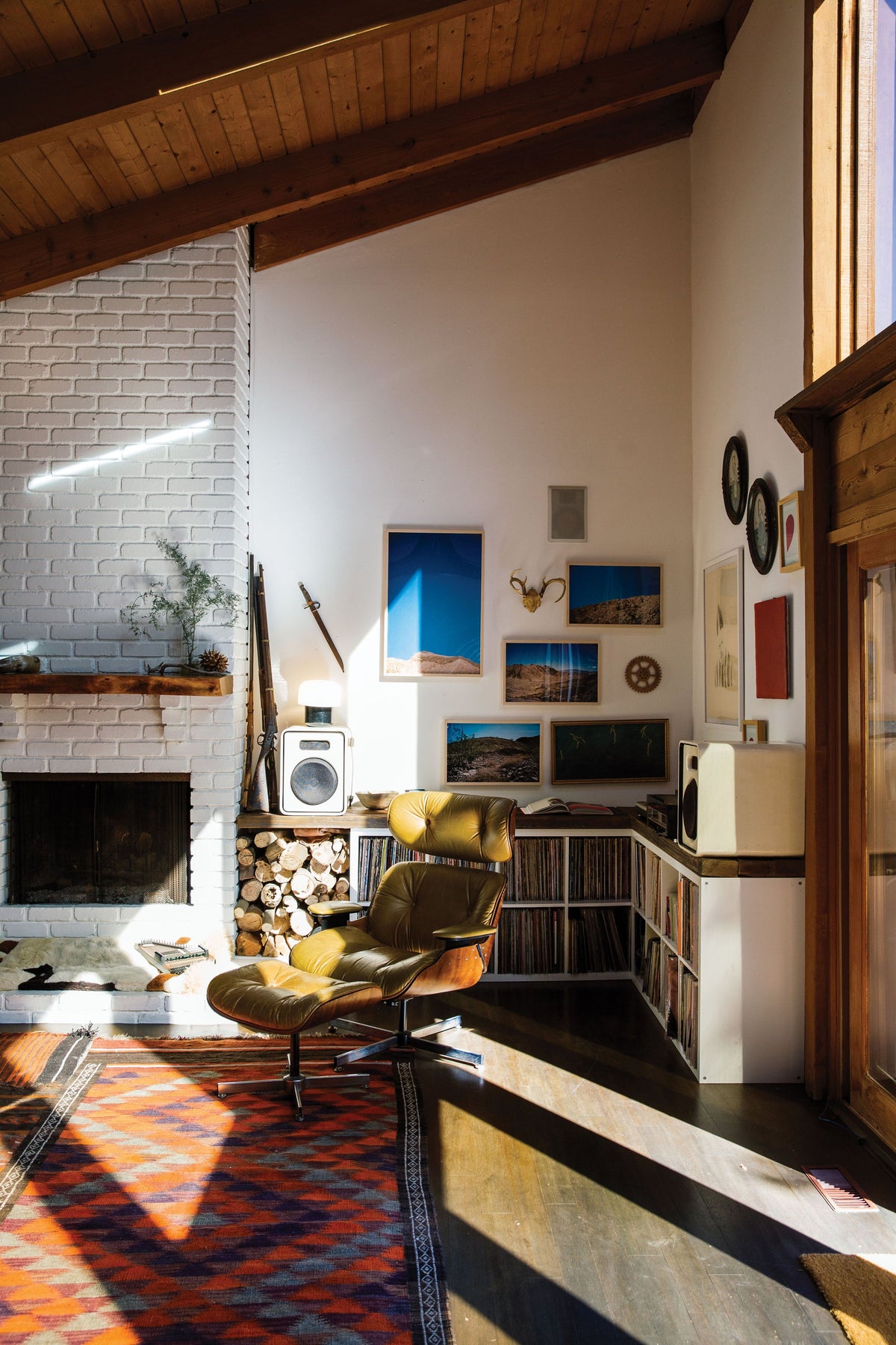 An artistic living room with a fireplace and a Surf Shacks : An Eclectic Compilation Of Creative Surfers Homes From Coast To Coast and Overseas rug.