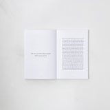 A "The Strength In Our Scars | Bianca Sparacino" book open on a white surface with text on it by Thought Catalog.