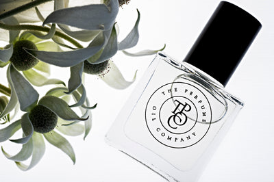 A collection of INK, inspired by Noir (Tom Ford) fragrance oil bottles sitting next to a flower.
Brand Name: The Perfume Oil Company.