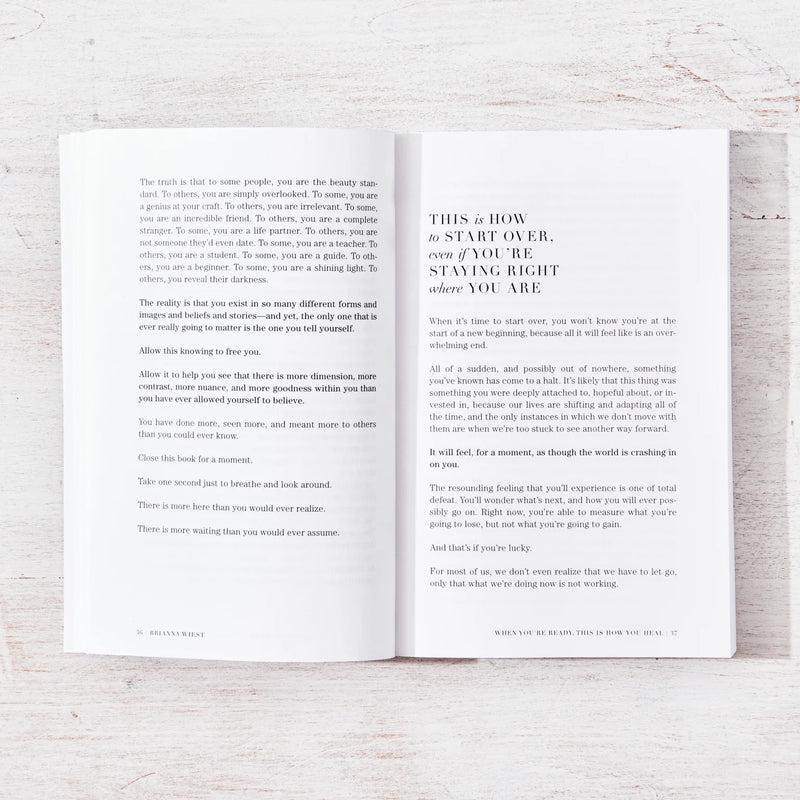 A motivational self-help book by Brianna Wiest open on a wooden table.