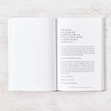 An open book, "When You're Ready, This Is How You Heal" by Brianna Wiest, providing inspiration and motivation for psychological healing, with a white cover on a wooden table.