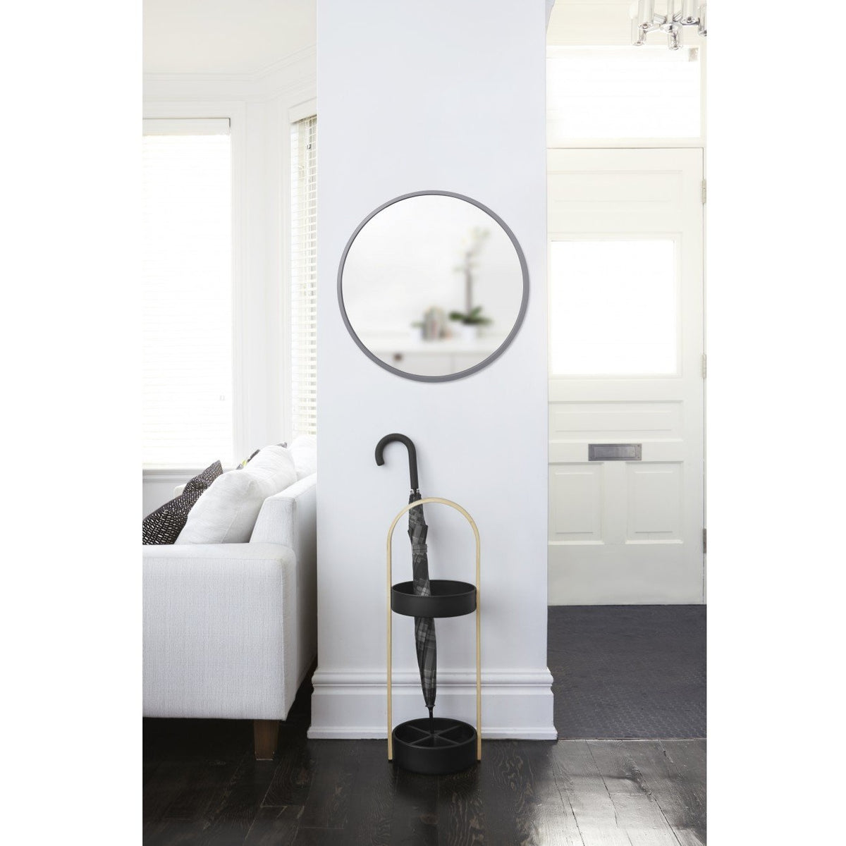 Umbra Hub 94cm grey round mirror mounted in a bright hallway