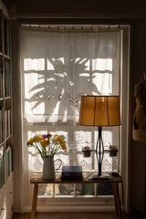 The shadow of a palm tree on a window, creating a tranquil home ambiance of Home | Victoria Alexander Books.