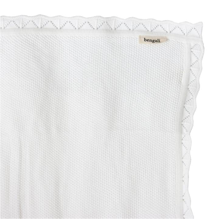 A White Heirloom Blanket with a lace trim by Bengali Collections.