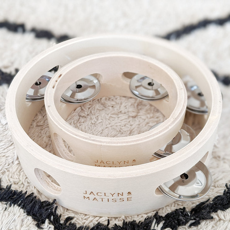 Two white tambourines on a black and white diamond rug