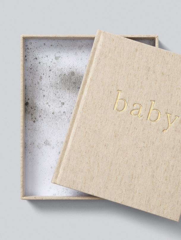 Oatmeal linen Write To Me baby journal sitting in its matching linen keepsake box