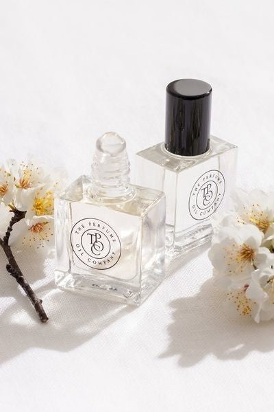 Two small bottles of NUDE, inspired by Beige (CC), from The Perfume Oil Company, on a white surface.