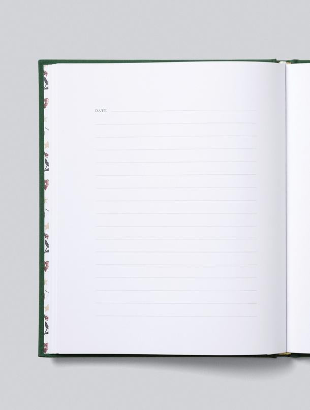 Christmas family book open to blank lined pages for writing memories