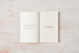 An "Come Home to Yourself | Déjà Rae" open book with a quote on it that explores the themes of solitude and relationships.