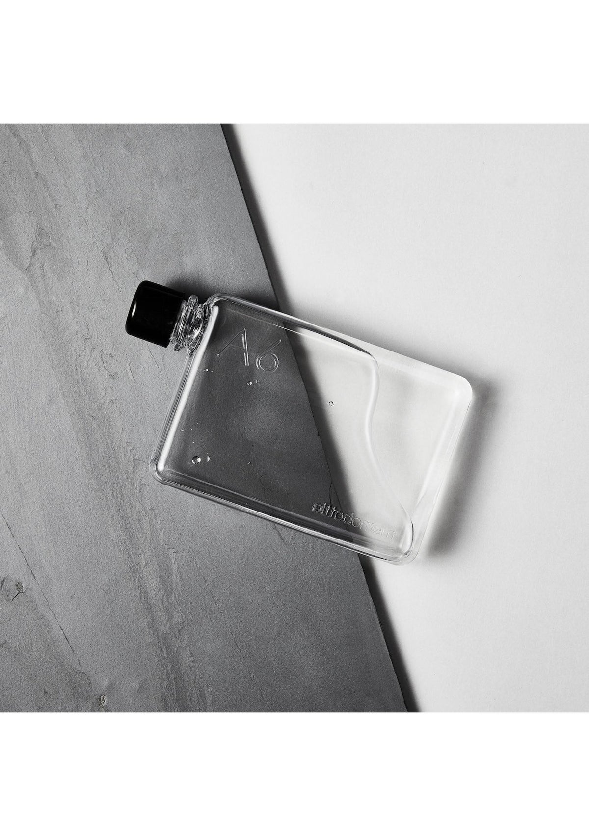 A MemoBottle A6 hydration bottle sitting on a gray surface.