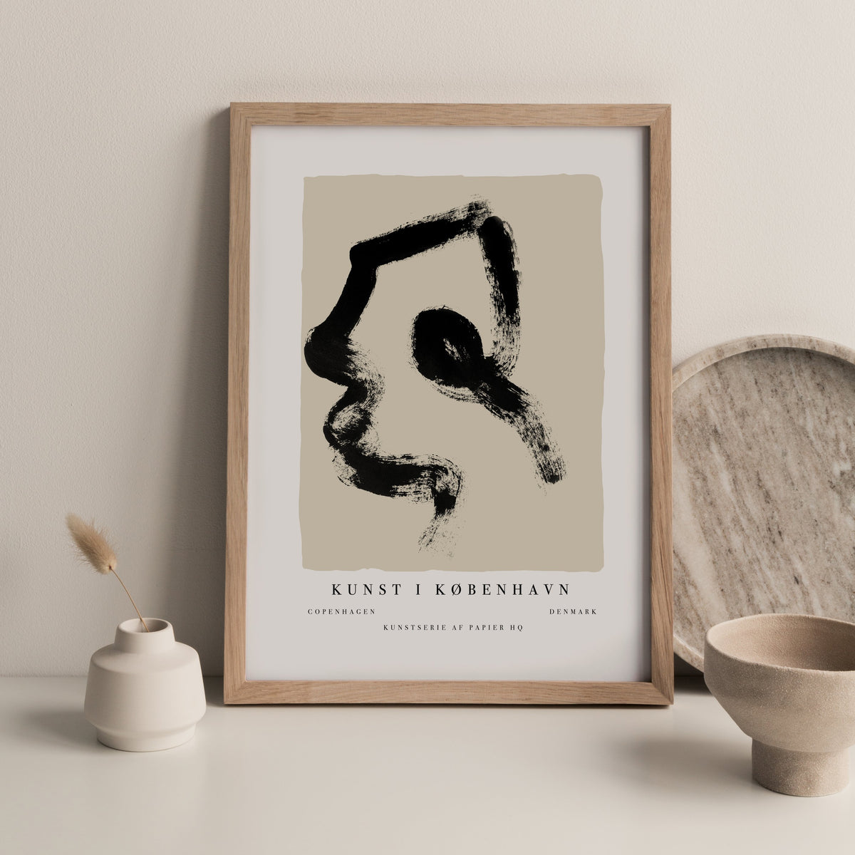 Copenhagen print in a timber frame beside a small vase and a stone bowl