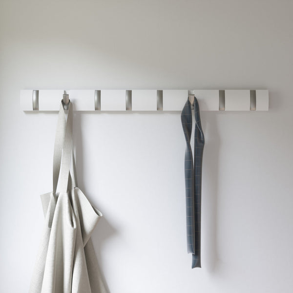 A Flip 8 Hook White coat rack from the Umbra range, featuring retractable hooks and adorned with a grey apron.