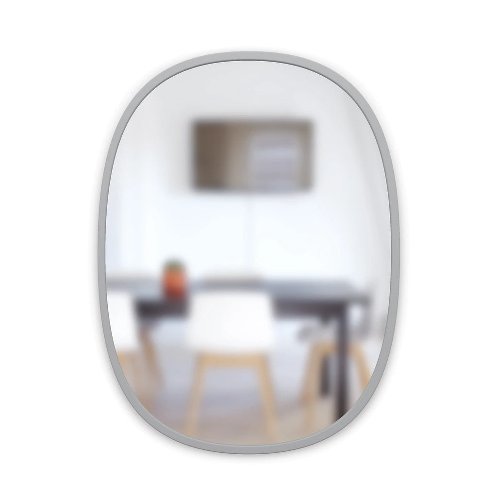 Grey Hub oval mirror reflecting a dining table and chairs