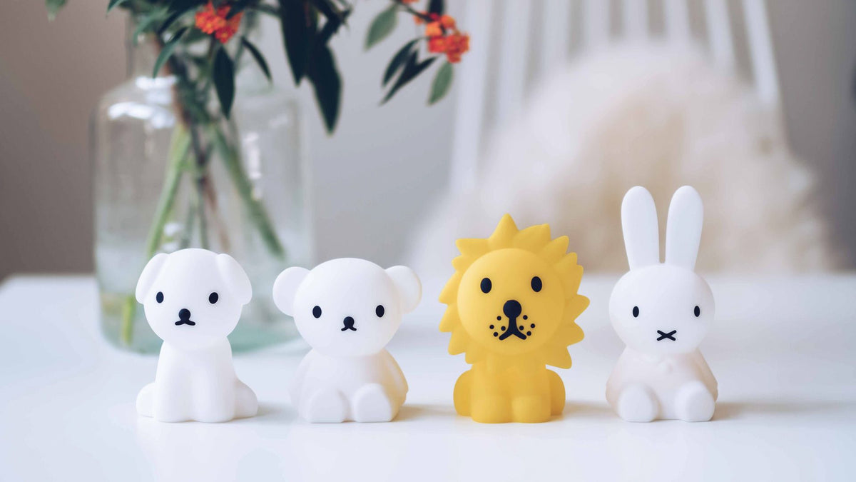 Range of animal night lamps, including a dog and a lion, beside plants