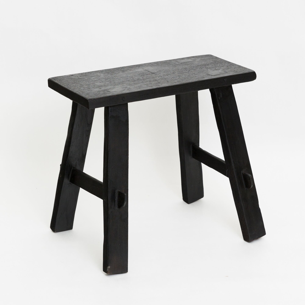 Black timber bench from a three-quarter angle, showing the mortised legs and lower stretcher rails