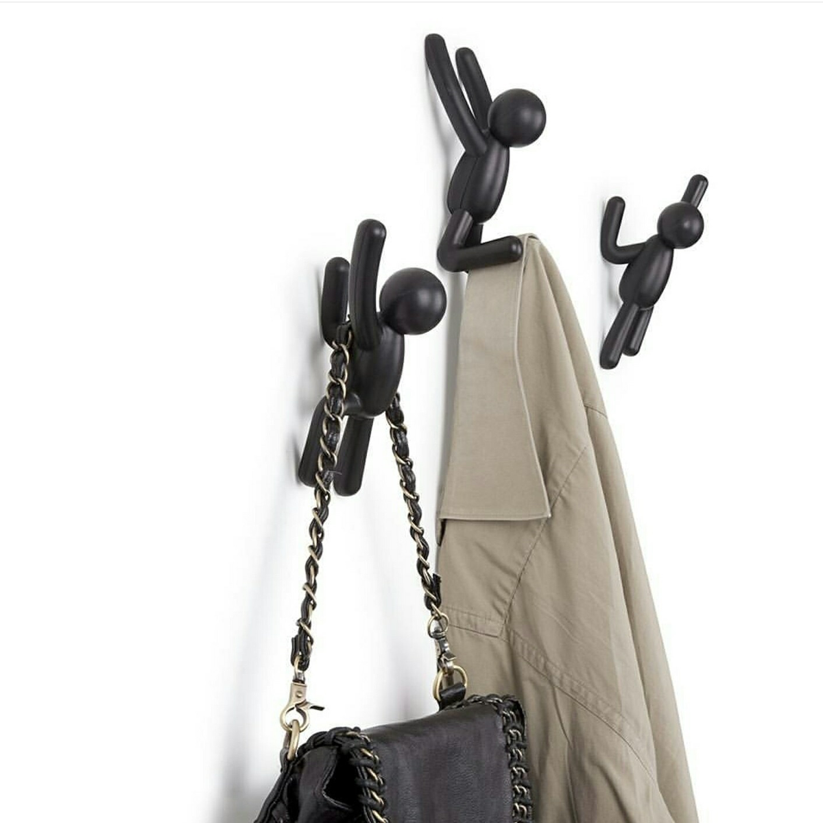 Umbra Buddy Hooks in black holding a handbag, doubling as playful wall decor