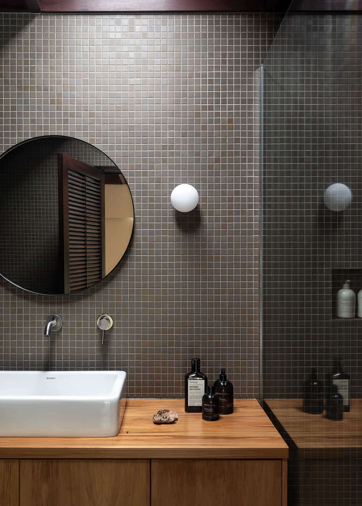 A bathroom with a sink and a mirror from Our Spaces - Contemporary New Zealand Interiors by Books.