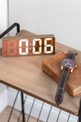 A sleek Karlsson Alarm Mirror LED clock adorns the table with its modern design.