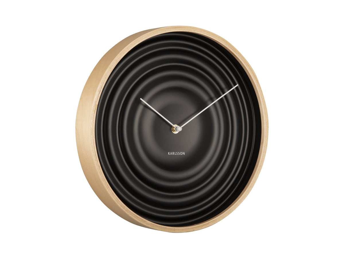 Black Scandi Ribble wall clock with a light timber rim, angled view