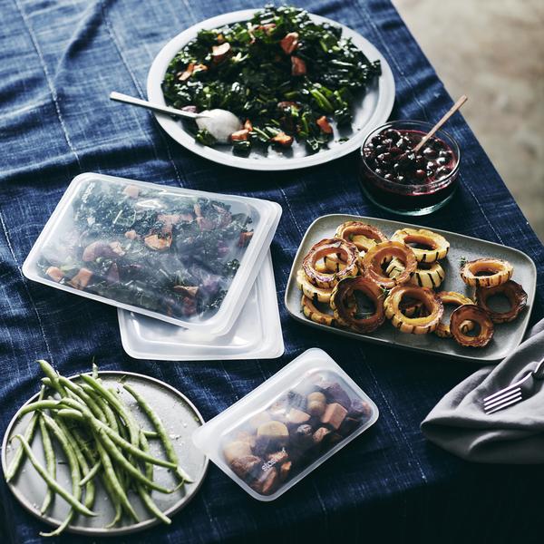 A STAND UP MINI-CLEAR bag full of food on a blue tablecloth.