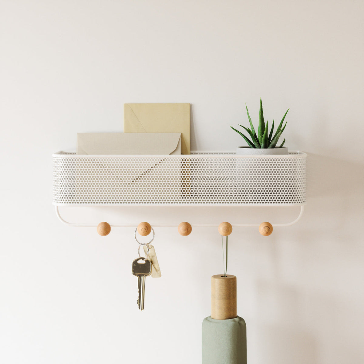 Umbra Estique Wall Organizer mounted in an entryway with keys on the wooden knob hooks