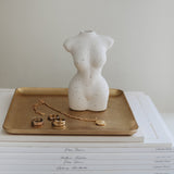 A white mannequin sitting on a Papier HQ brass tray.