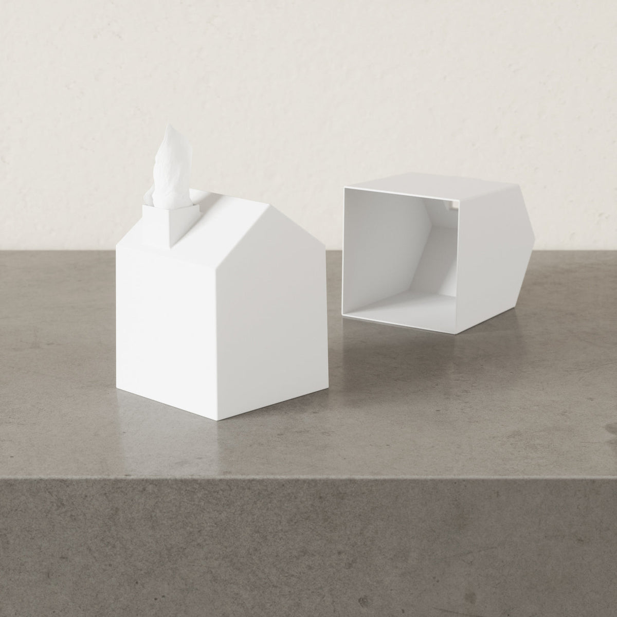 Umbra Casa tissue box cover lifted off its base, showing how it slips over a tissue box