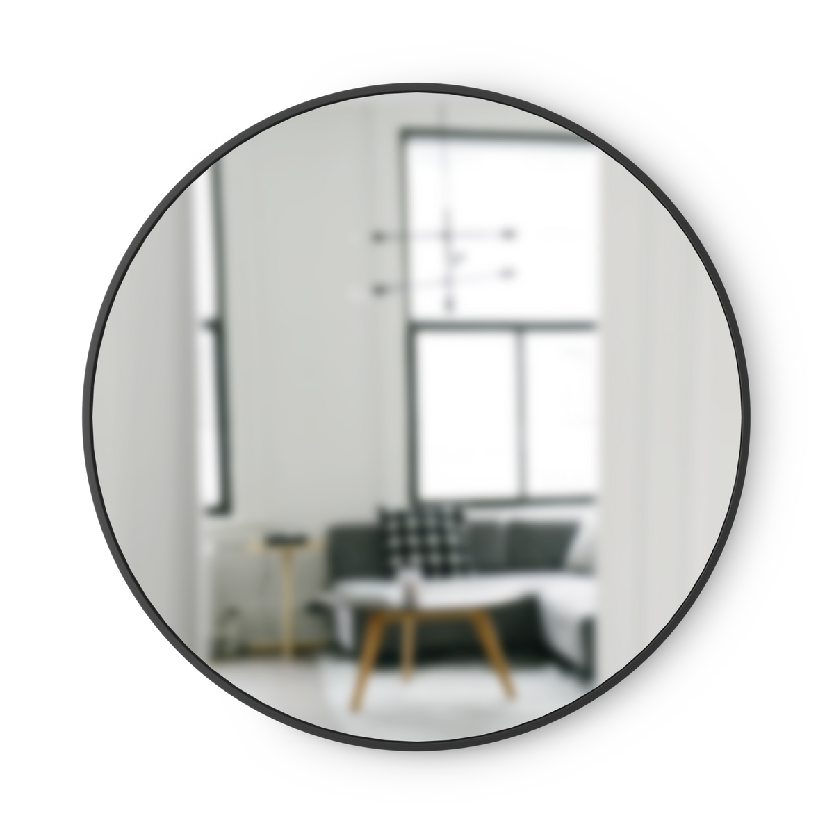 A modern Umbra Hub Mirror 45cm Black with a black frame in a living room.